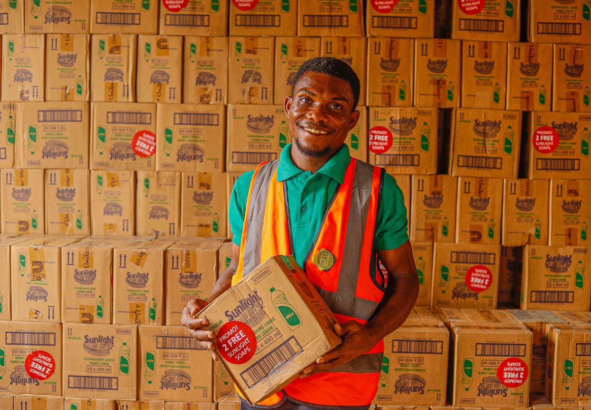Distribution worker handling a carton in a warehouse