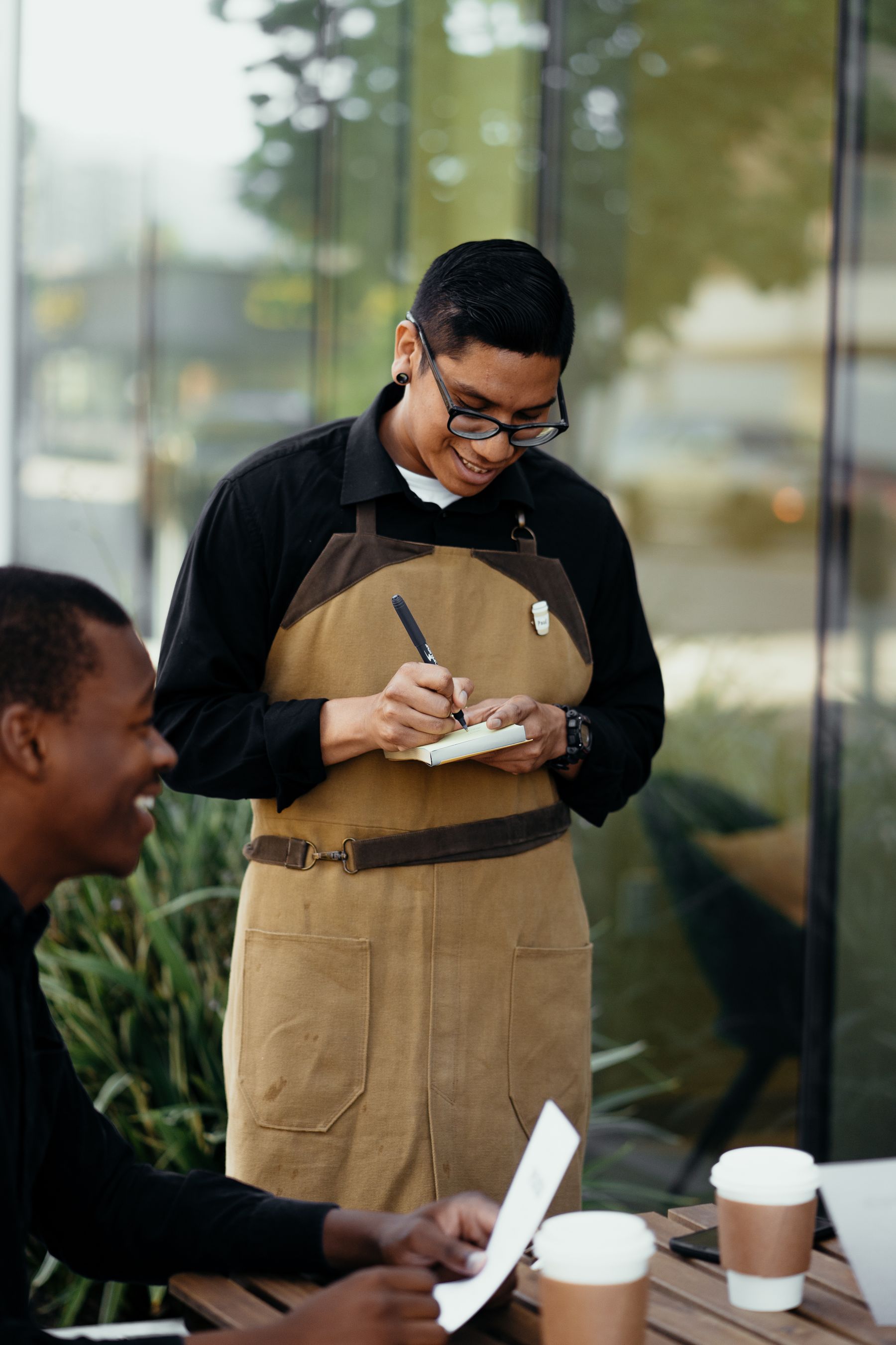 Waiter taking an order from guests outside a café